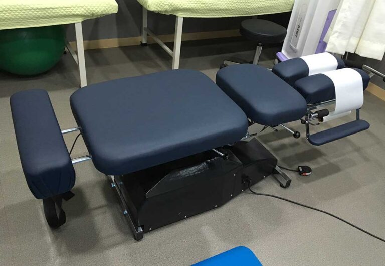 Person seated at a desk adjusting a monitor while keeping the neck aligned and shoulders relaxed.